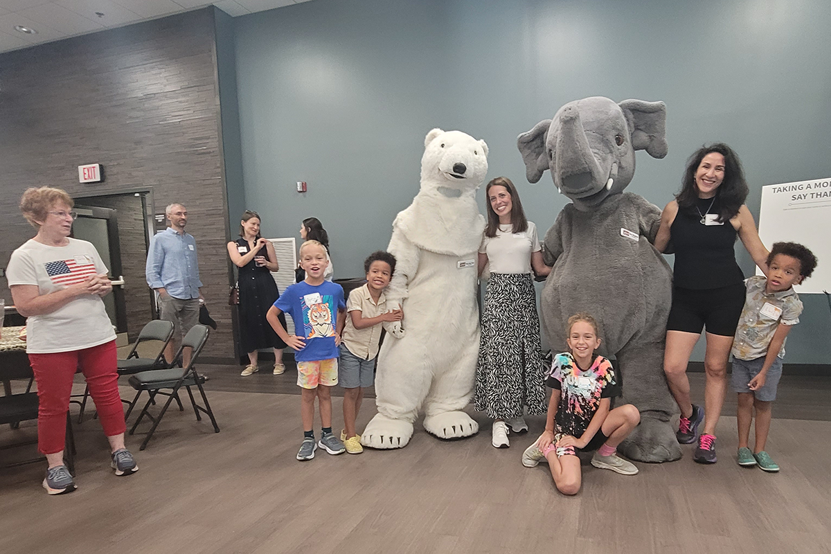 Kids and adults posing with the Columbus Zoo's polar bear and elephant mascots.  People are conversing in the background as the GRC's 15th year anniversary concludes!