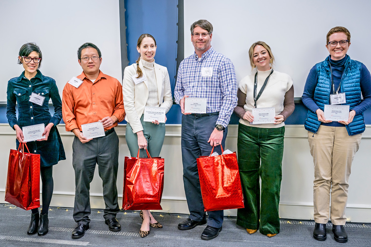 2025 Kudos award winners posing with awards plaque in their hands