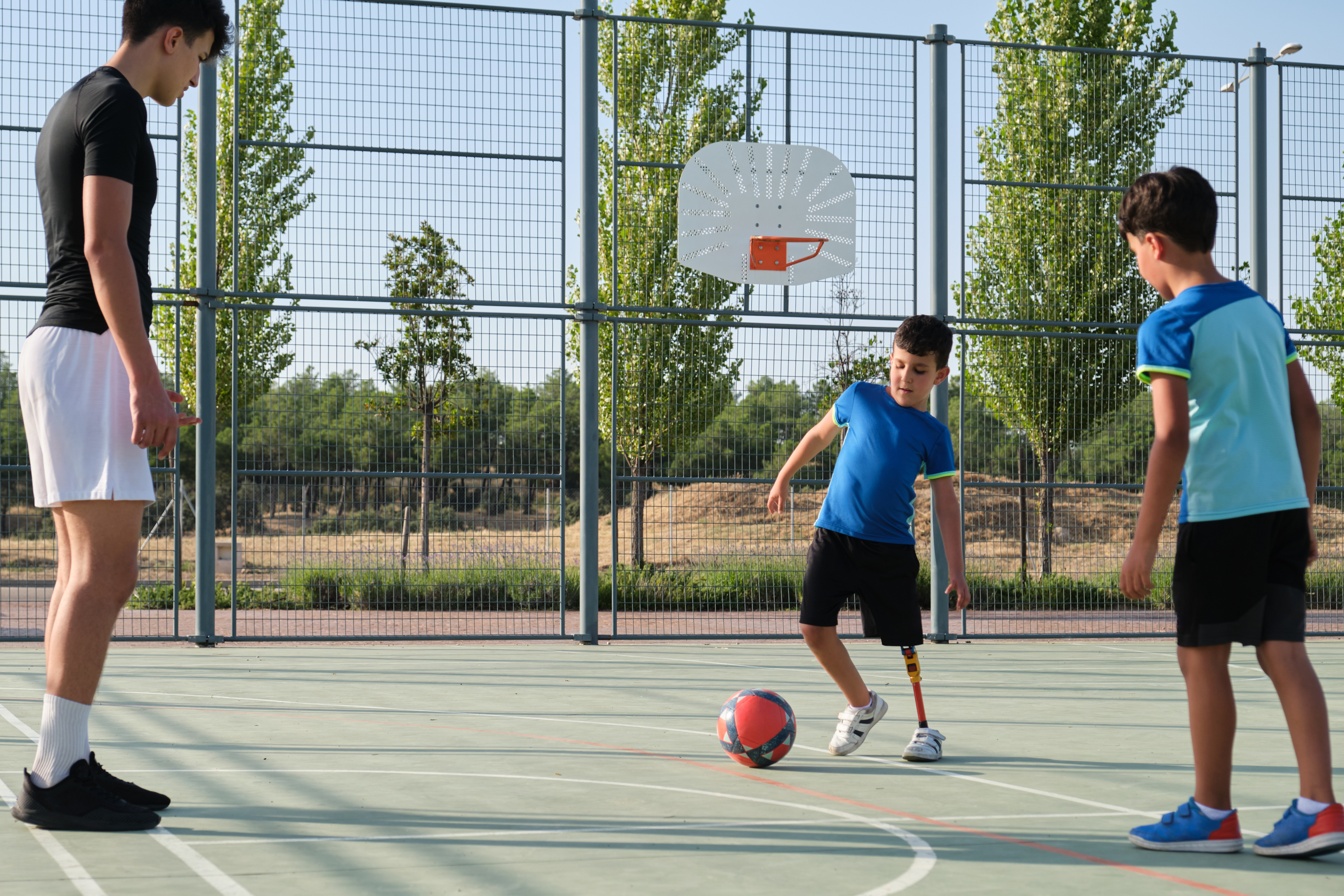 A child with a mobility disability playing soccer with other children