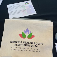 2024 Women's Health Equity Symposium marketing materials. Logo centered with the tagline: Re-envisioning women's healthcare and research.