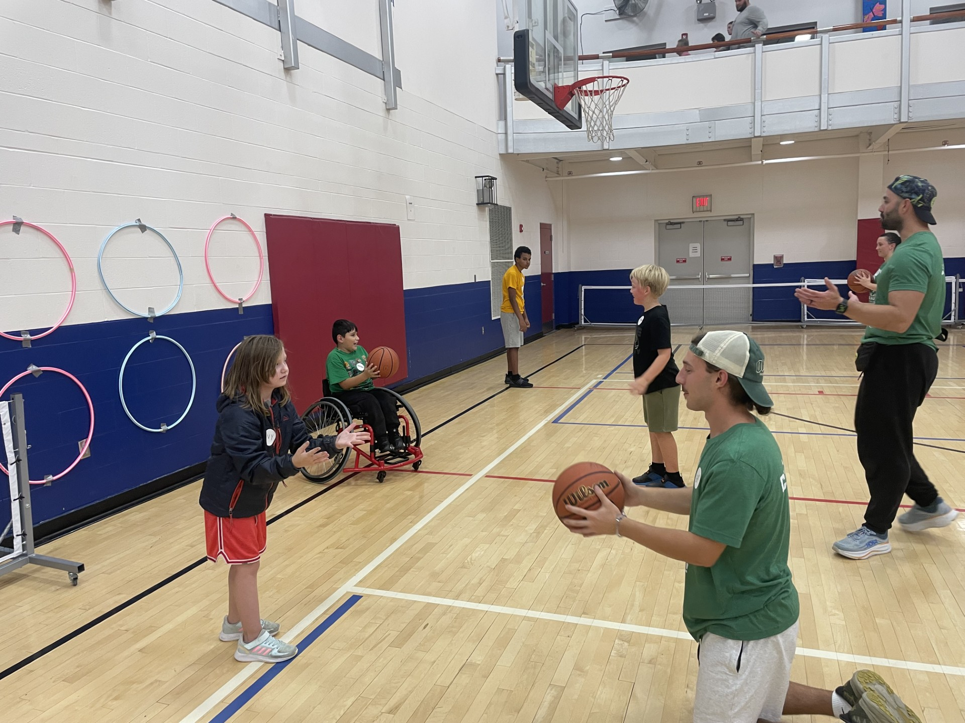 Group of youth with and without disabilities doing a basketball drill with coaches in an Athens gym