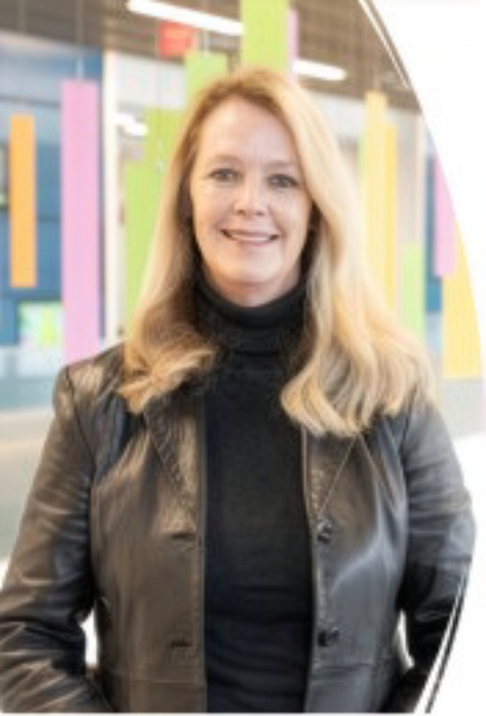 Eva Szigethy, MD, PhD standing before an art exhibit
