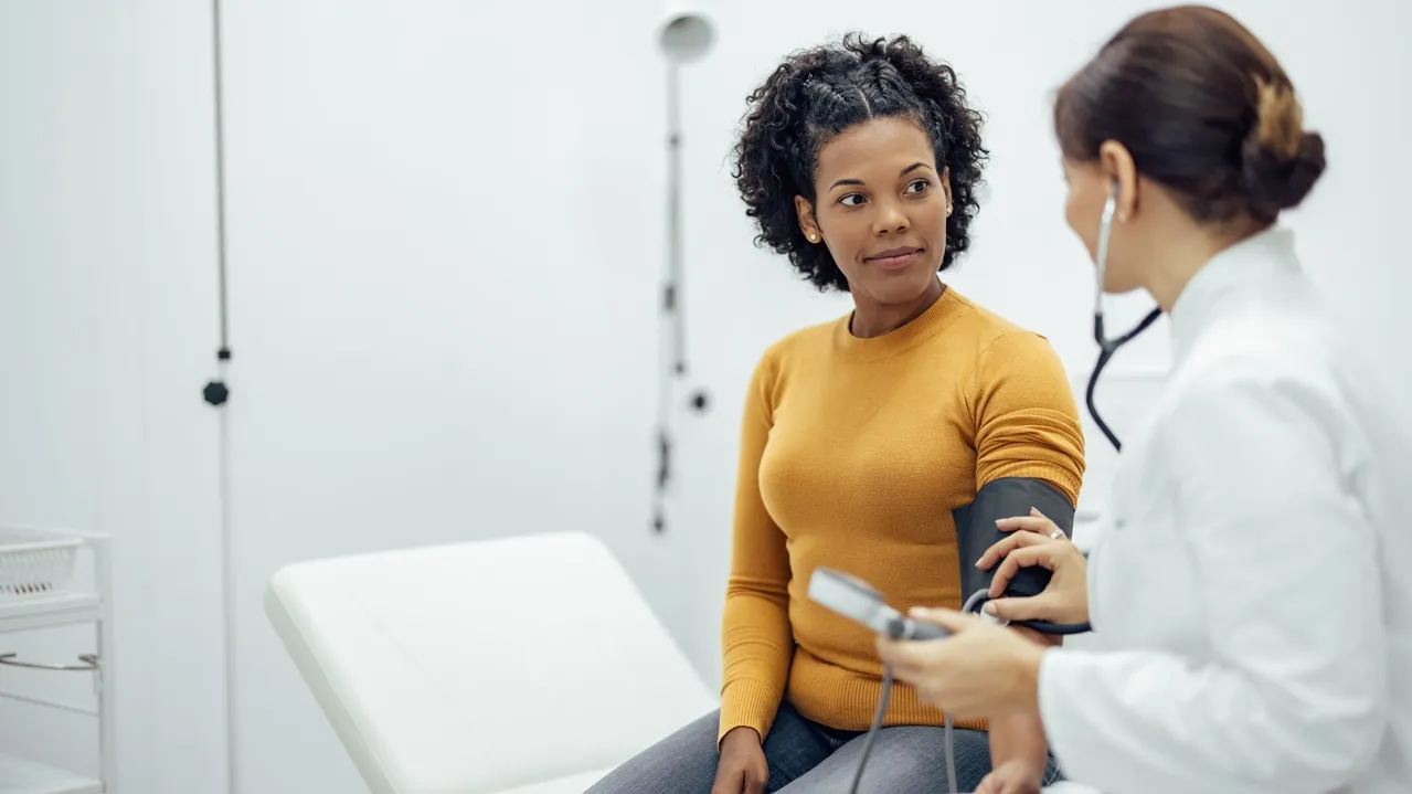 Image of a women getting her blood pressure checked by a doctor