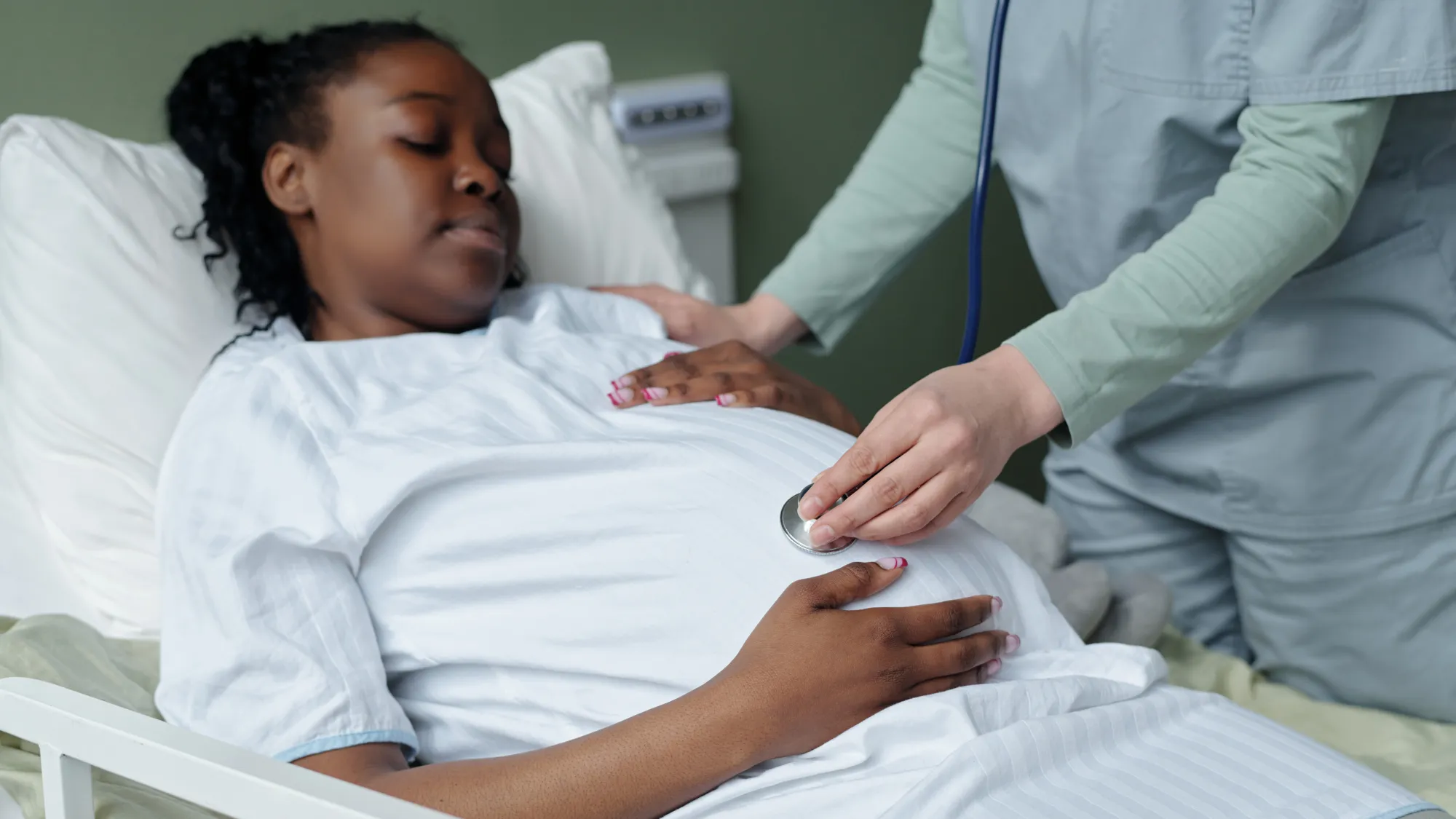 Relaxing, mother-to-be lying comfortably while nurse providing prenatal care