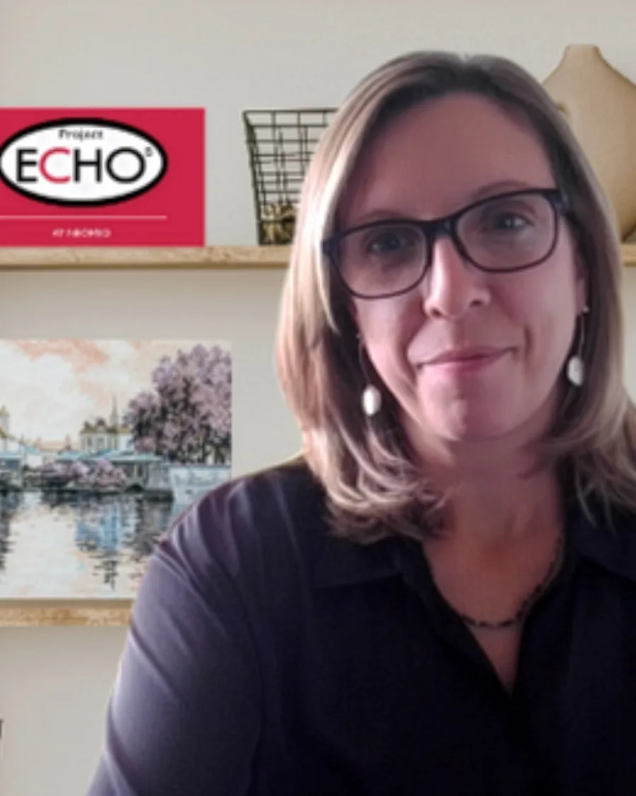 Headshot of Jami Brewer, AA, in her office with a Project Echo plaque.
