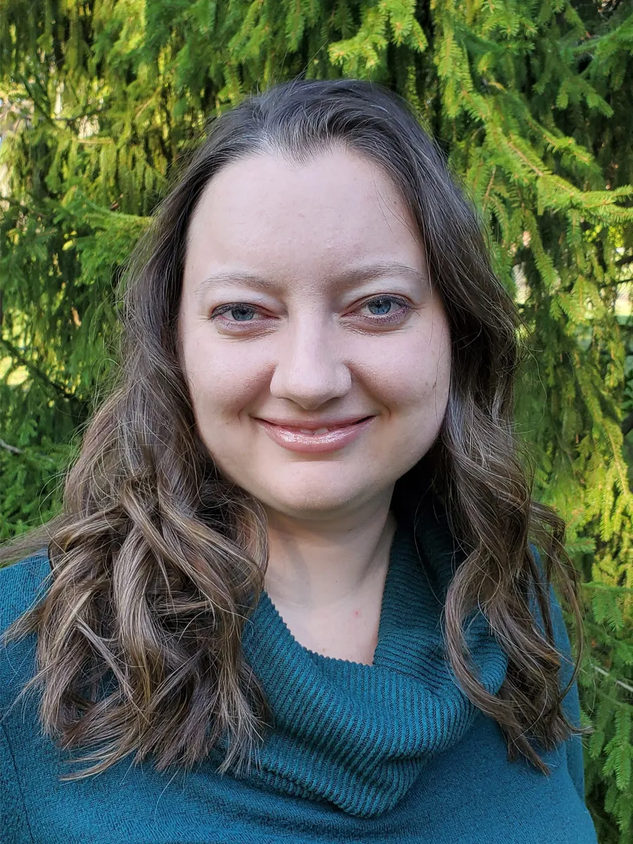 A brunette woman wearing a green sweater