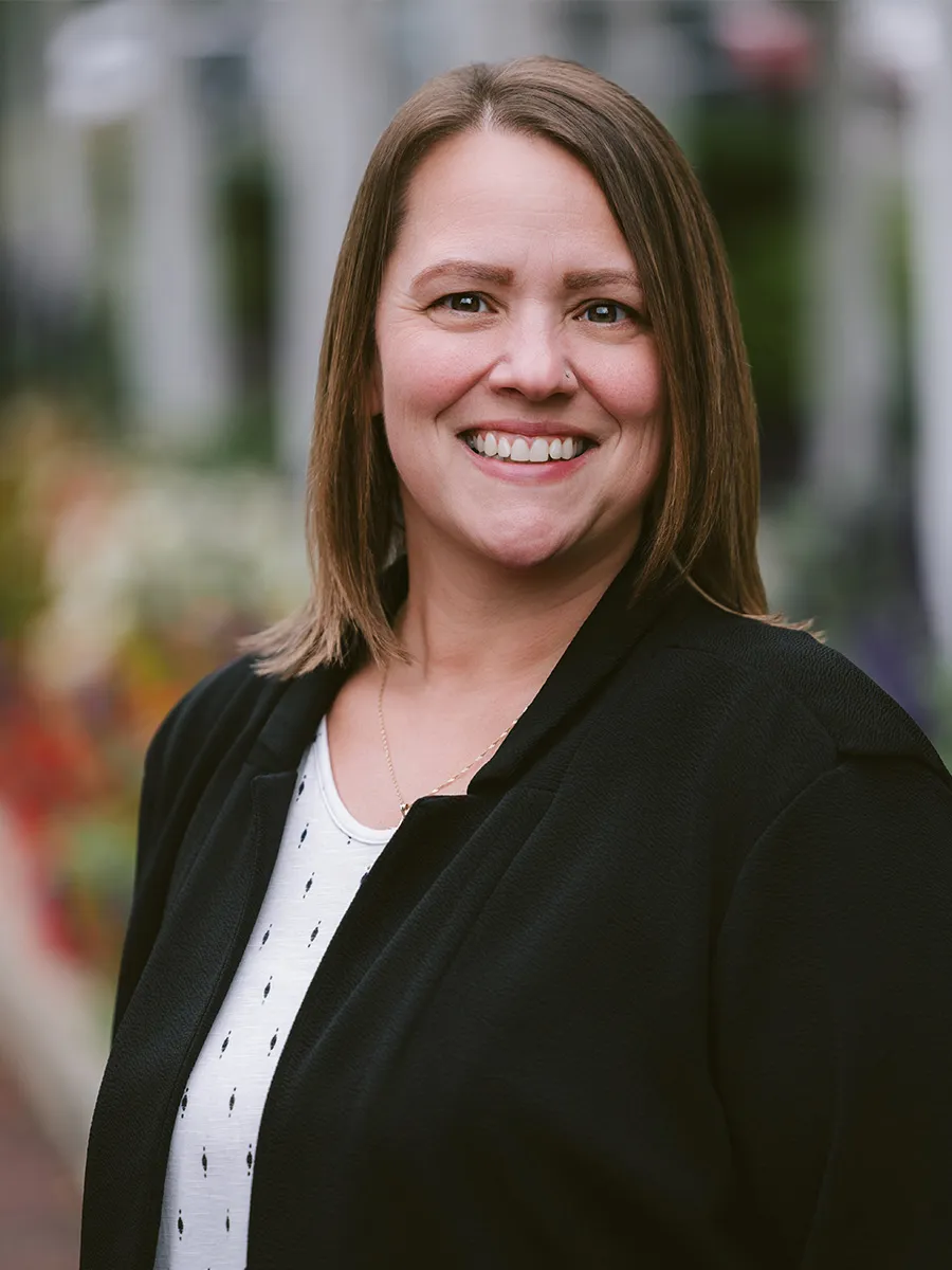 Headshot of Tia DeLong, a woman with short brown hair wearing a black blazer