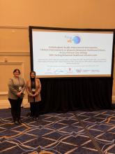 "GRC staff Abigail Ezzeldin and Ceviren Busra (left to right) pose in front of their presentation's Focus on ME title slide